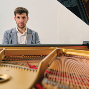 Christian Pastorino photographed looking through the piano with the lid up
