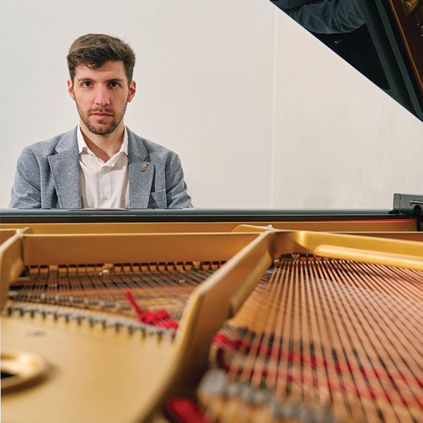 Christian Pastorino photographed looking through the piano with the lid up