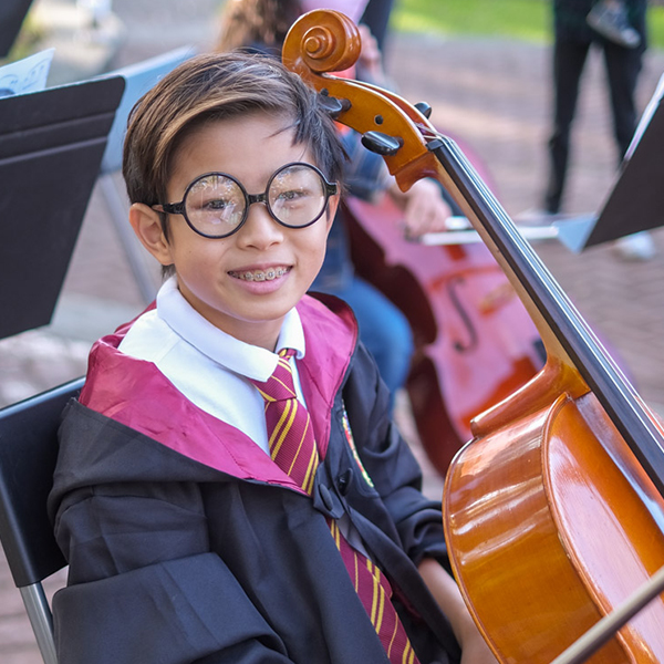 Student dressed as Harry Potter with a cello