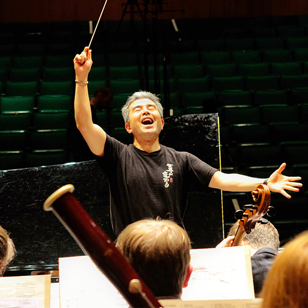 Man in black shirt conducting an orchestra