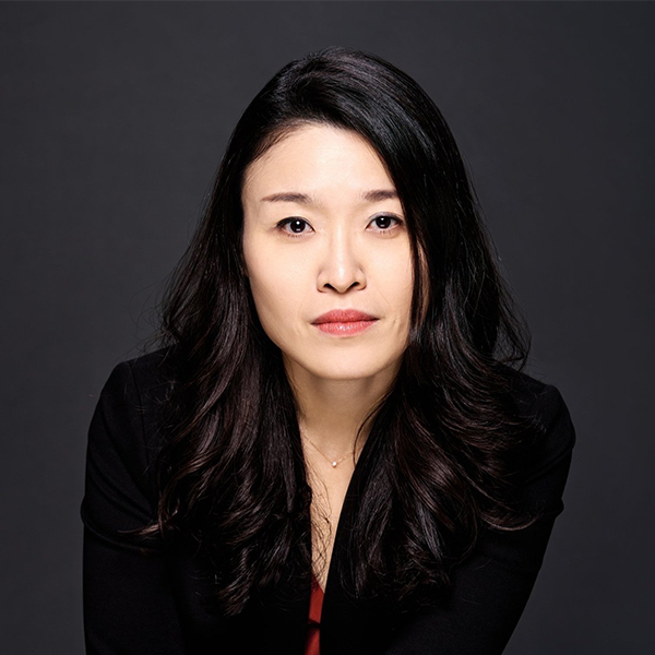 Asian woman dressed in black againist a black background