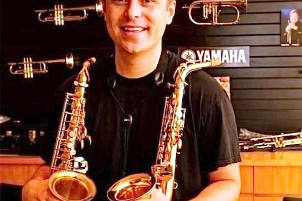 Nathan Childers holding two saxophones