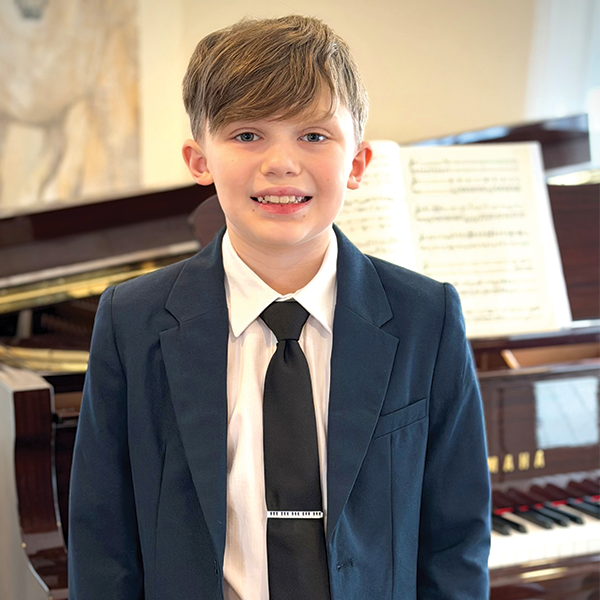 Boy standing in front of a piano