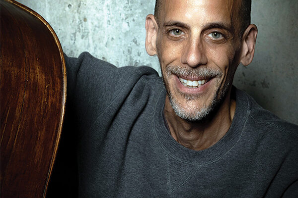 Man Smiling holding a double bass
