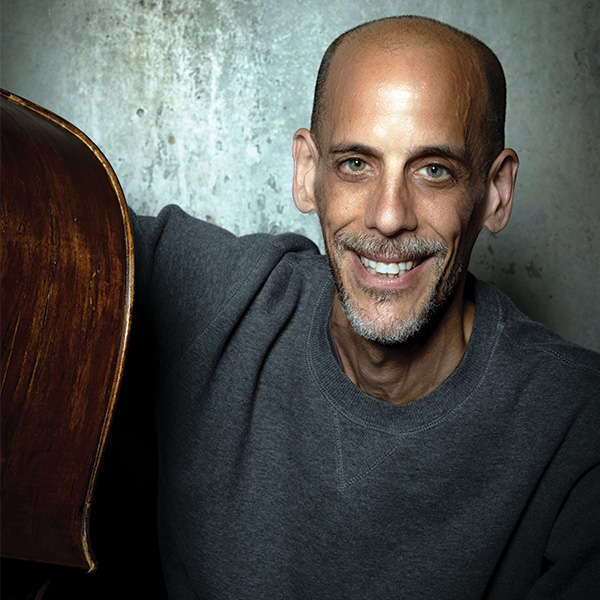 Man Smiling holding a double bass