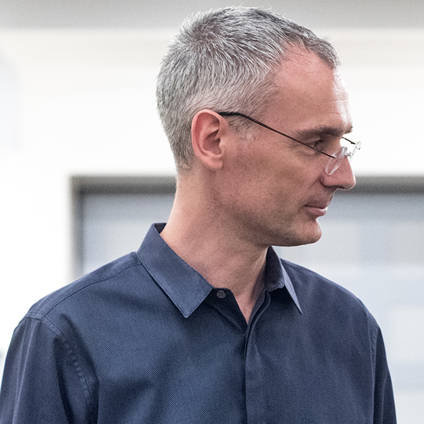 Man in blue shirt with glasses looking sideways