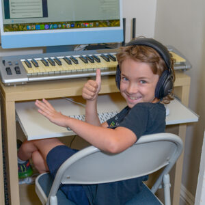 Young boy giving thumbs up in Music Lab