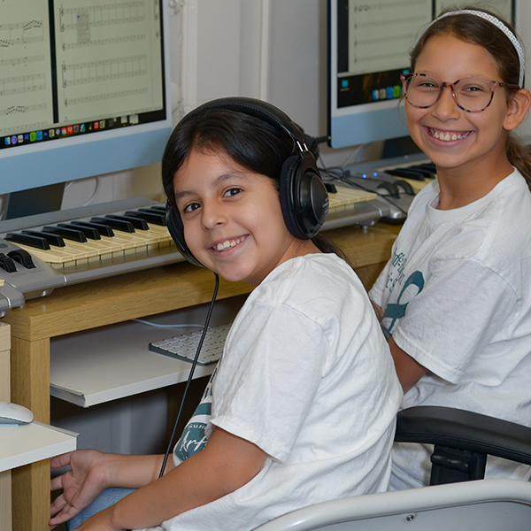 young girls in a music tech lab smiling