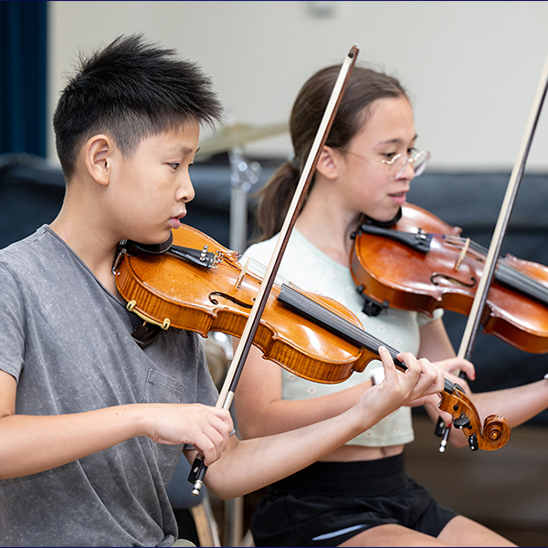 Teen boy and Teen girl playing violins