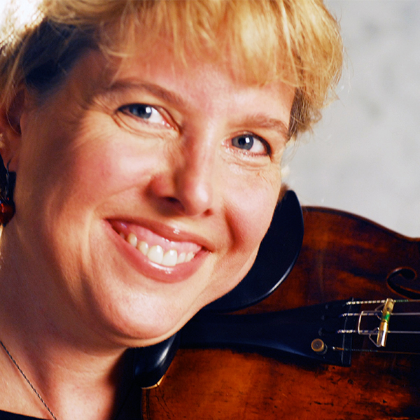 Woman with blond hair, smiling and holding a violin under her chin