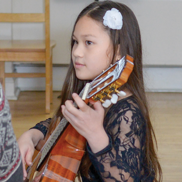 Young girl playing a guitar