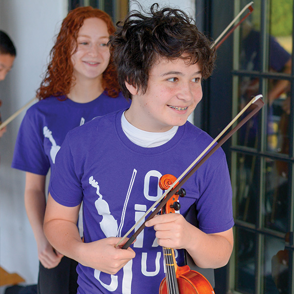 Boy and Girl smiling carrying violas