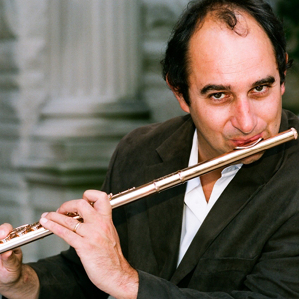 man in white shirt and black jacket playing the flute